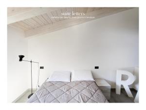 a bedroom with a bed with white walls and a wooden ceiling at Casa da Zoe in Spoleto