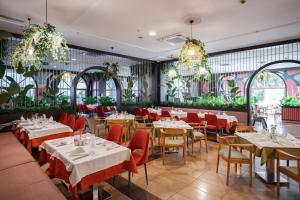 a restaurant with white tables and red chairs at Megasaray Westbeach Antalya in Antalya