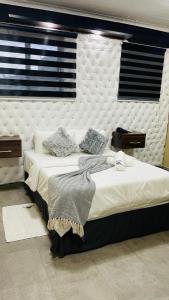 a bedroom with two beds and a white headboard at Naldorado Executive Villa in Nelspruit