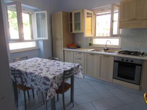 eine Küche mit einem Tisch und einem Tischtuch darauf in der Unterkunft Mareluna Casa Del Mare in Ventotene