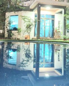 a house with its reflection in a pool of water at Homestay Happy Home Sóc Sơn in Hanoi