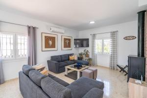 ein Wohnzimmer mit 2 blauen Sofas und einem TV in der Unterkunft Casita Los Garranchos in Córdoba