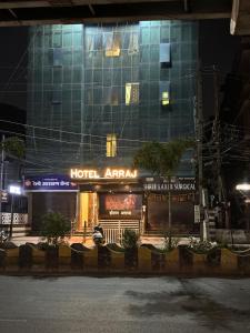 Hotel ARRAJ, Raipur في رايبور: مدخل الفندق امام مبنى في الليل