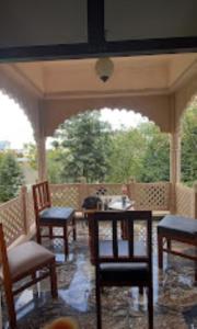 a screened in porch with chairs and a table at Hotel Comfort Regency in Bharatpur