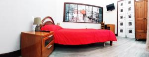 a bedroom with a red bed and a window at Tenerife BnB in Las Lagunas