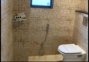 baño con ducha, aseo y ventana en Hotel Comfort Regency, en Bharatpur