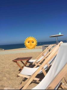 a sun head is hanging over chairs on a beach at Villa patio Capbreton in Capbreton