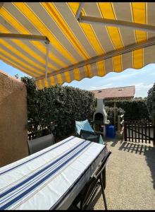 a patio with a yellow and blue umbrella at Villa patio Capbreton in Capbreton