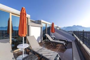 a balcony with chairs and umbrellas on a roof at Megasaray Westbeach Antalya in Antalya