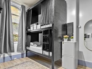 a black bunk bed in a room with a window at Sydney Pod Hotels - Darling Harbour in Sydney
