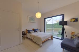 ein Schlafzimmer mit einem Bett und einem großen Fenster in der Unterkunft Villa Serenity in Chambourcy