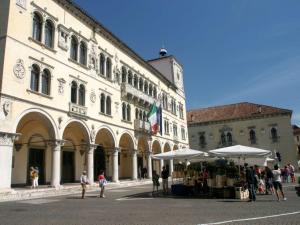 um grupo de pessoas em pé em frente a um edifício em Monolocale Ninetta Dolomiti bellunesi em Belluno