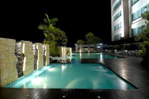 a swimming pool at night with a building at Sunee Grand Hotel and Convention Center in Ubon Ratchathani