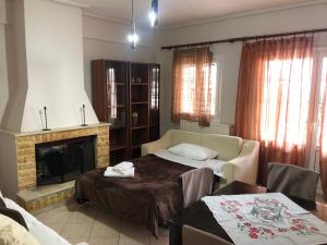 a living room with a bed and a fireplace at Loulas Beach House Skaloma in Skaloma