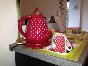 a red tea pot sitting on a counter next to two mugs at Ballylough in Voulangis