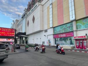 a group of people riding motorcycles down a city street at Sunee Grand Hotel and Convention Center in Ubon Ratchathani