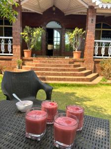 ein Tisch mit vier Gläsern rosafarbener Getränke darauf in der Unterkunft Sai Leela Bungalow - Villa with Private Pool in Mahabaleshwar + 31 Fotos