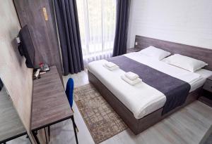 - une chambre avec un lit et 2 serviettes dans l'établissement Minguzar Hotel, à Tachkent
