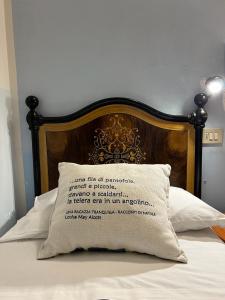 een bed met een houten hoofdeinde en een kussen bij Hotel Morri - il BIBLIHOTEL in Riccione