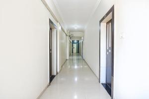 a corridor of an empty building with white walls and a long hallway at FabHotel Yashraj Inn in Vagholi