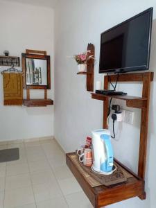 Habitación con TV y mesa con cafetera. en Chenang Indah Chalets, en Pantai Cenang