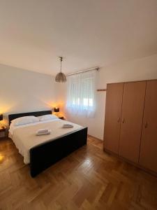 een slaapkamer met een groot bed en een houten vloer bij Apartment Nelly- self check-in in Zadar