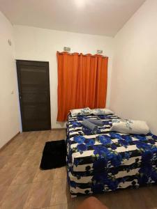1 dormitorio con cama y cortina de color naranja en Juliet Places en Lopes