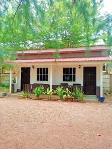 una casa con muchas plantas delante de ella en Chenang Indah Chalets, en Pantai Cenang