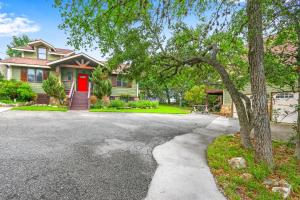 a house with a red door and a driveway at Clutter Falls Retreat - Guest House in New Braunfels
