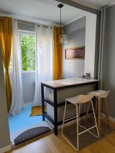 a desk and two chairs in a room with a window at Radu Acomodation in Bucharest