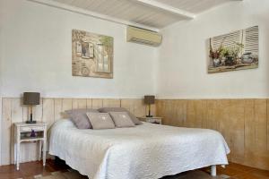 a bedroom with a white bed and two tables at Domaine Au Coeur des Alpilles in Maussane-les-Alpilles