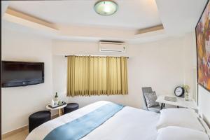 een hotelkamer met een bed en een televisie bij ELIOT HOTELs in Ho Chi Minh-stad