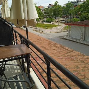 a balcony with a table and an umbrella at Frini Apartments and Studios in Paralia Katerinis