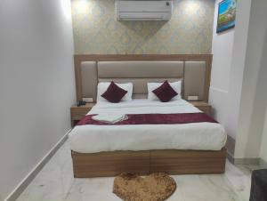 a bedroom with a large bed with red pillows at Hotel Decent -Mahipalpur, Delhi Airport,Aerocity in New Delhi