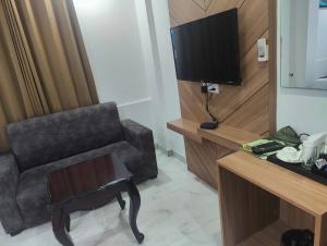 a living room with a chair and a television at Hotel Decent -Mahipalpur, Delhi Airport,Aerocity in New Delhi