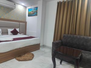 ニューデリーにあるHotel Decent Aerocity - Mahipalpur, Delhi Airportのベッドルーム1室(ベッド1台、ソファ、テーブル付)
