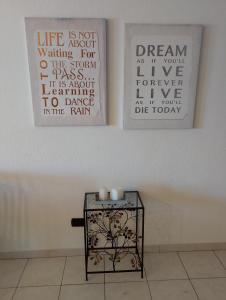 two posters on a wall with a table with candles at Casa Vacanze Chiara in Olbia