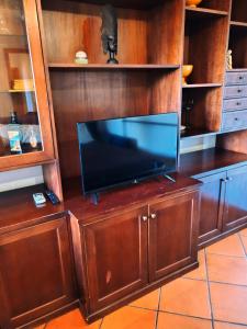 a flat screen tv on a wooden entertainment center at Talenti house in Rome