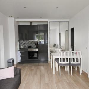 eine Küche und ein Esszimmer mit einem Tisch und Stühlen in der Unterkunft Résidence Hôtel Le Relais Amélie in Clamart