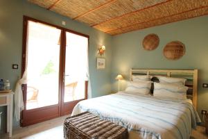 a bedroom with a bed and a large window at Via Bahia - Maison d'hôtes in Biscarrosse