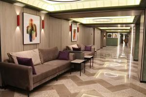 a lobby with couches and tables in a building at Hotel Kazzhol Almaty in Almaty