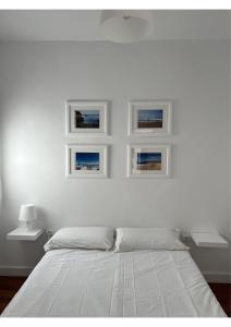 una camera bianca con un letto e tre immagini sul muro di Sherry-House & Parking a Jerez de la Frontera