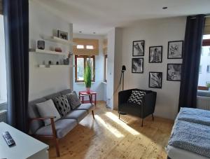 a living room with a couch and a chair at Peters Apartments - Zentrale Innenstadtlage in Fulda