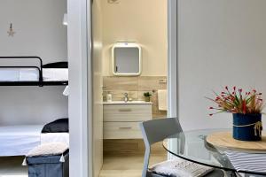 a small apartment with a bedroom and a table and a mirror at Gocciadoro guest apartment in Solanas