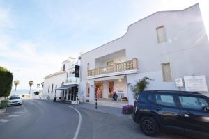 a car parked in front of a white building at Centralissimo Monolocale con Terrazzino Vista Mare in Leuca +15 photos