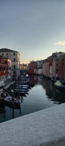 a river with boats in a city with buildings at Cas'Ale in Chioggia
