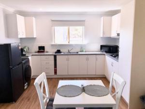 a small kitchen with a table and a table and chairs at MULBERRY LODGE in Woodridge