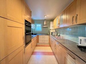 a large kitchen with wooden cabinets and appliances at London Central Acton House in London