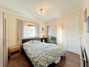 a bedroom with a bed and a desk and a window at London Central Acton House in London