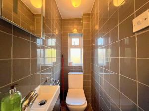 ein Bad mit einem WC und einem Waschbecken in der Unterkunft London Central Acton House in London